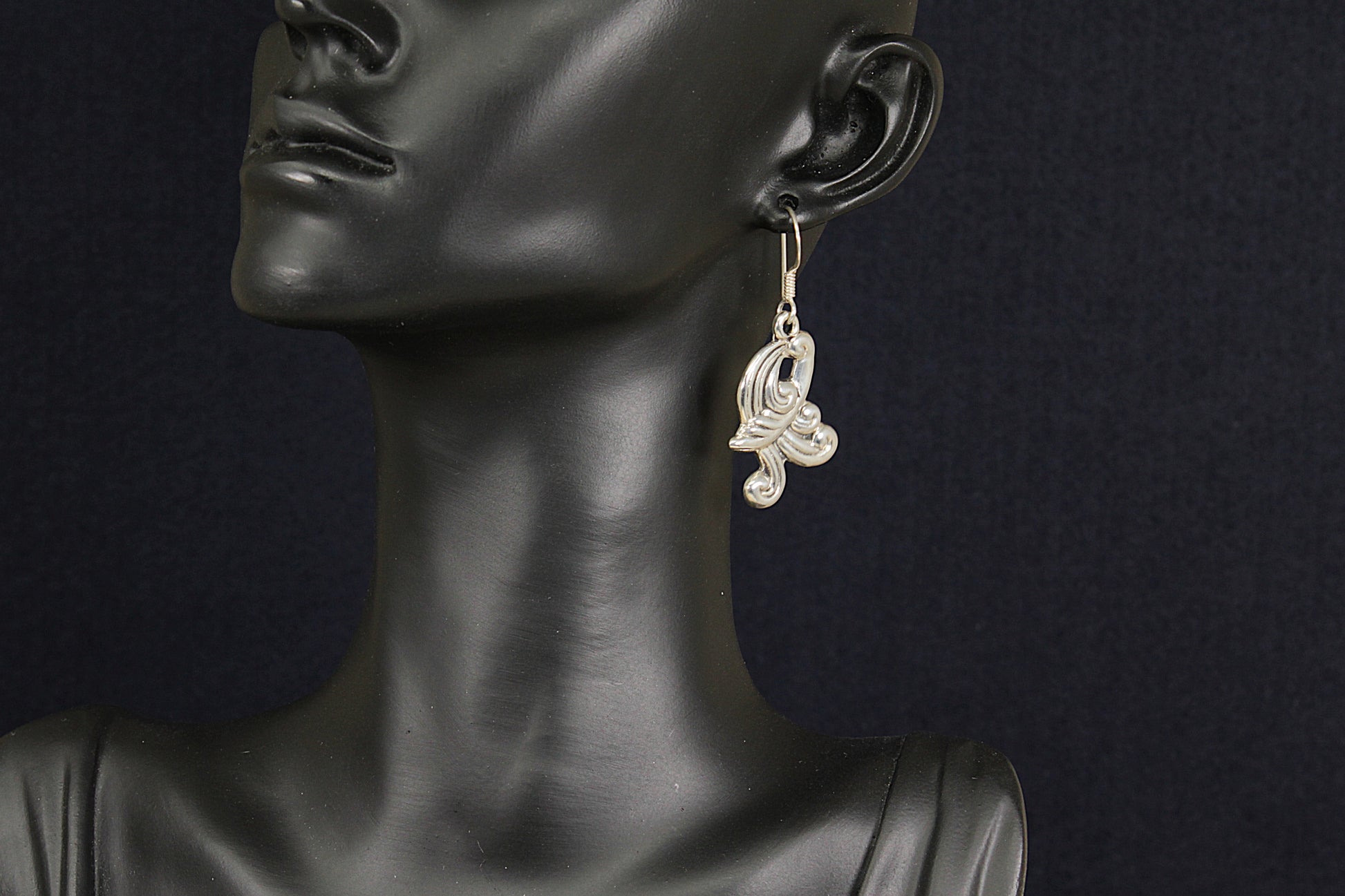 Earring on a mannequin against a dark background