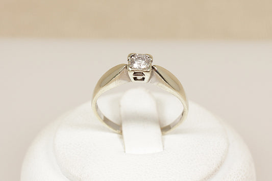White gold diamond solitaire engagement ring on a white cushion