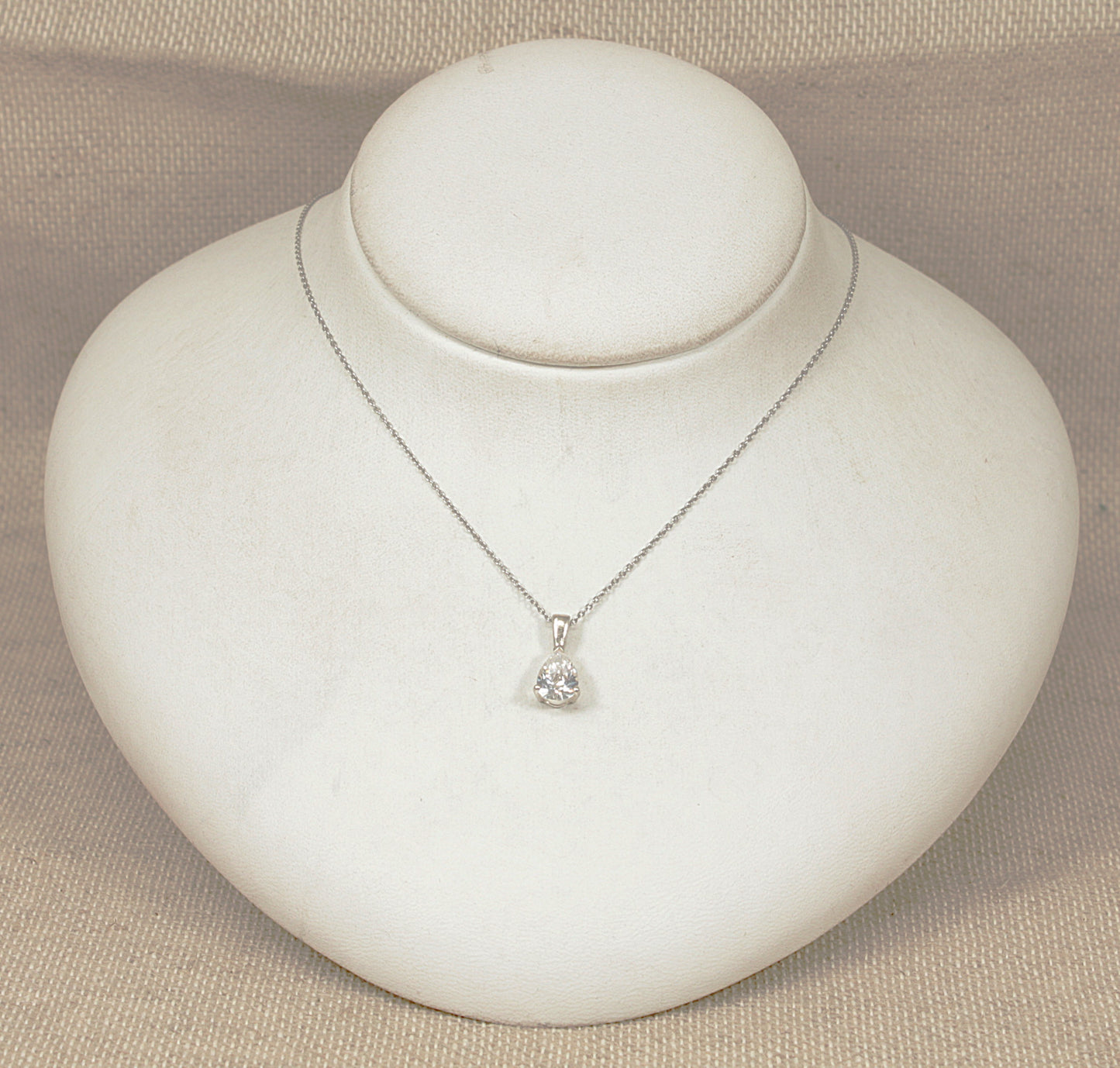 Silver necklace with a pendant on a white jewelry display
