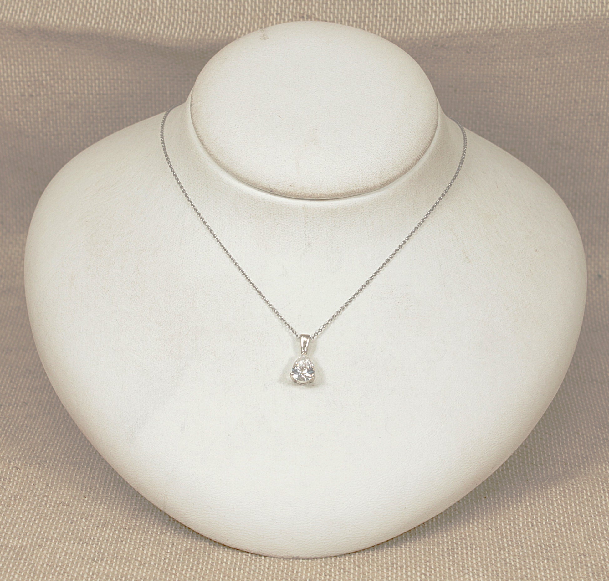 Silver necklace with a pendant on a white jewelry display