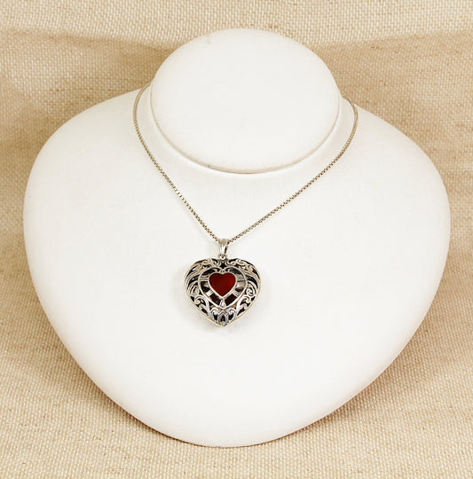 Heart-shaped pendant necklace on a white bust against a beige background