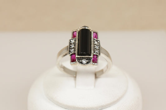 Silver art deco ring with black gemstone and pink stones on a white stand