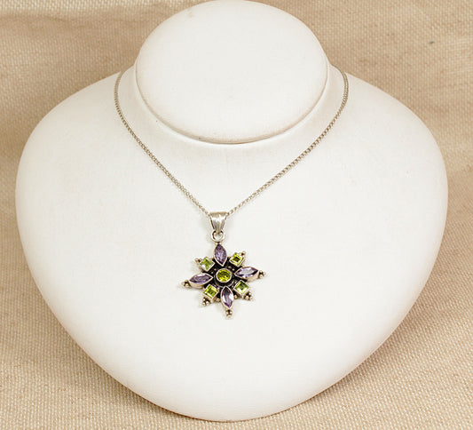 Necklace with a star-shaped pendant on a white stand against a beige background