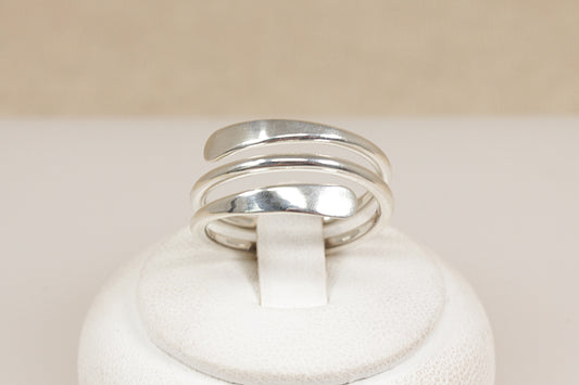 Silver coil ring on a white rind stand  with a beige background