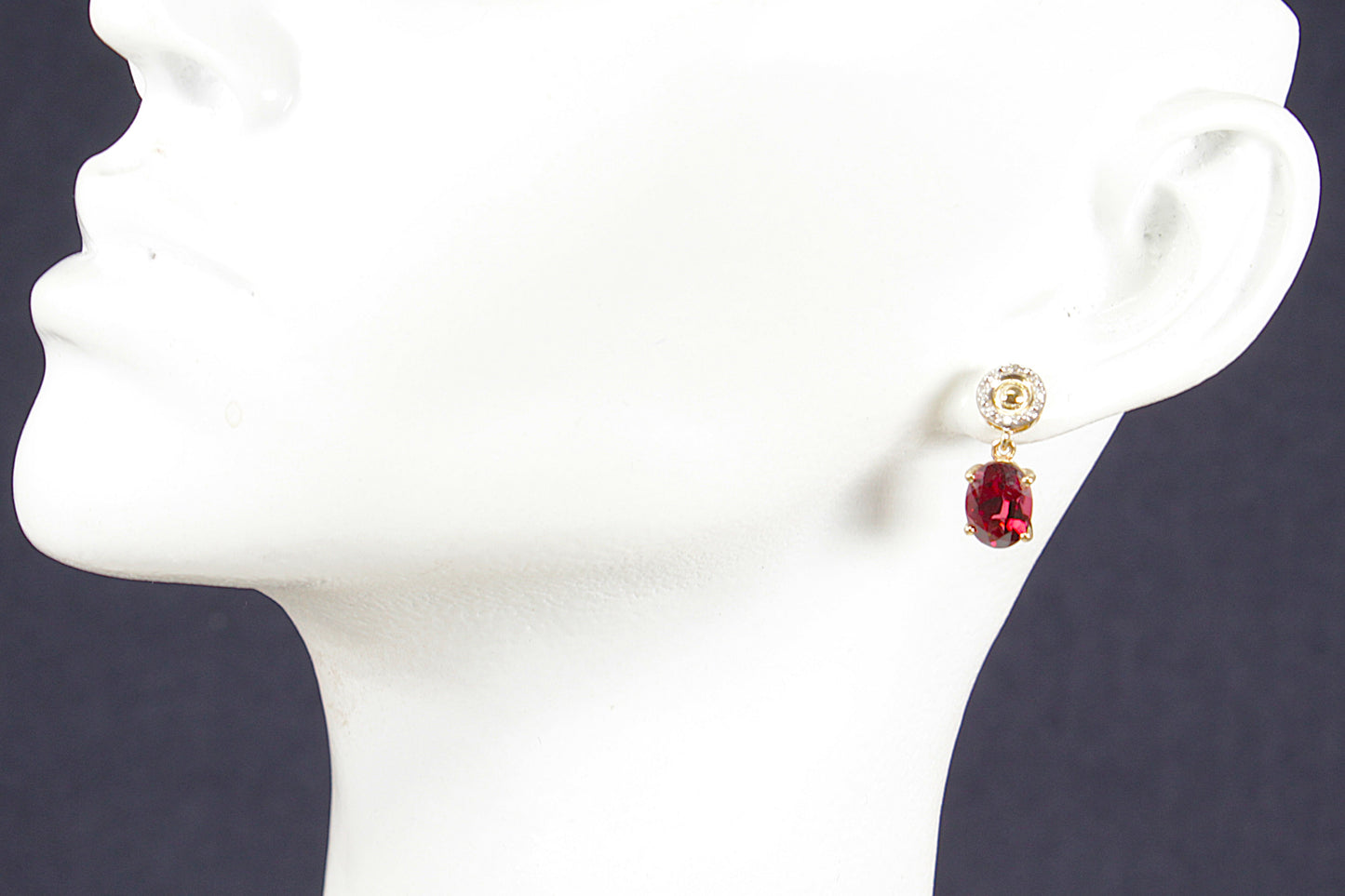 10ct gold red Garnet and diamond gemstone earrings on a white mannequin head against a dark background