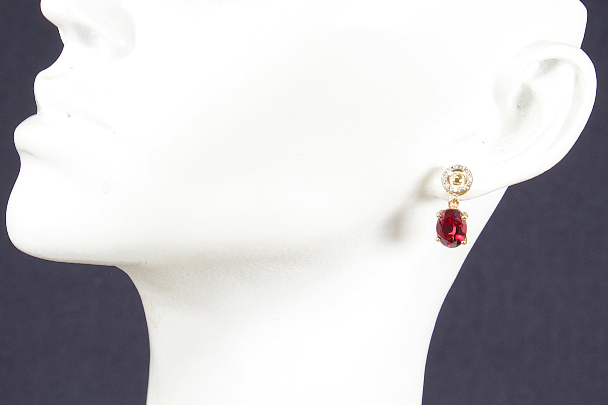 10ct gold red Garnet and diamond gemstone earrings on a white mannequin head against a dark background
