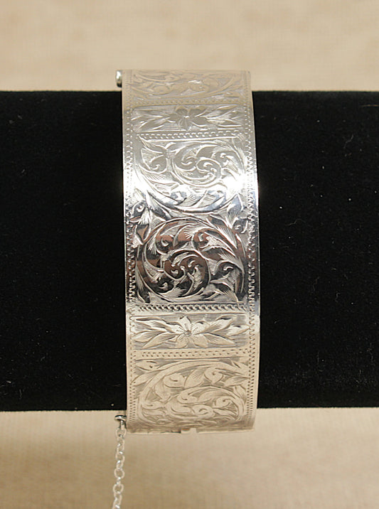 Vintage silver bracelet with intricate patterns on a black background