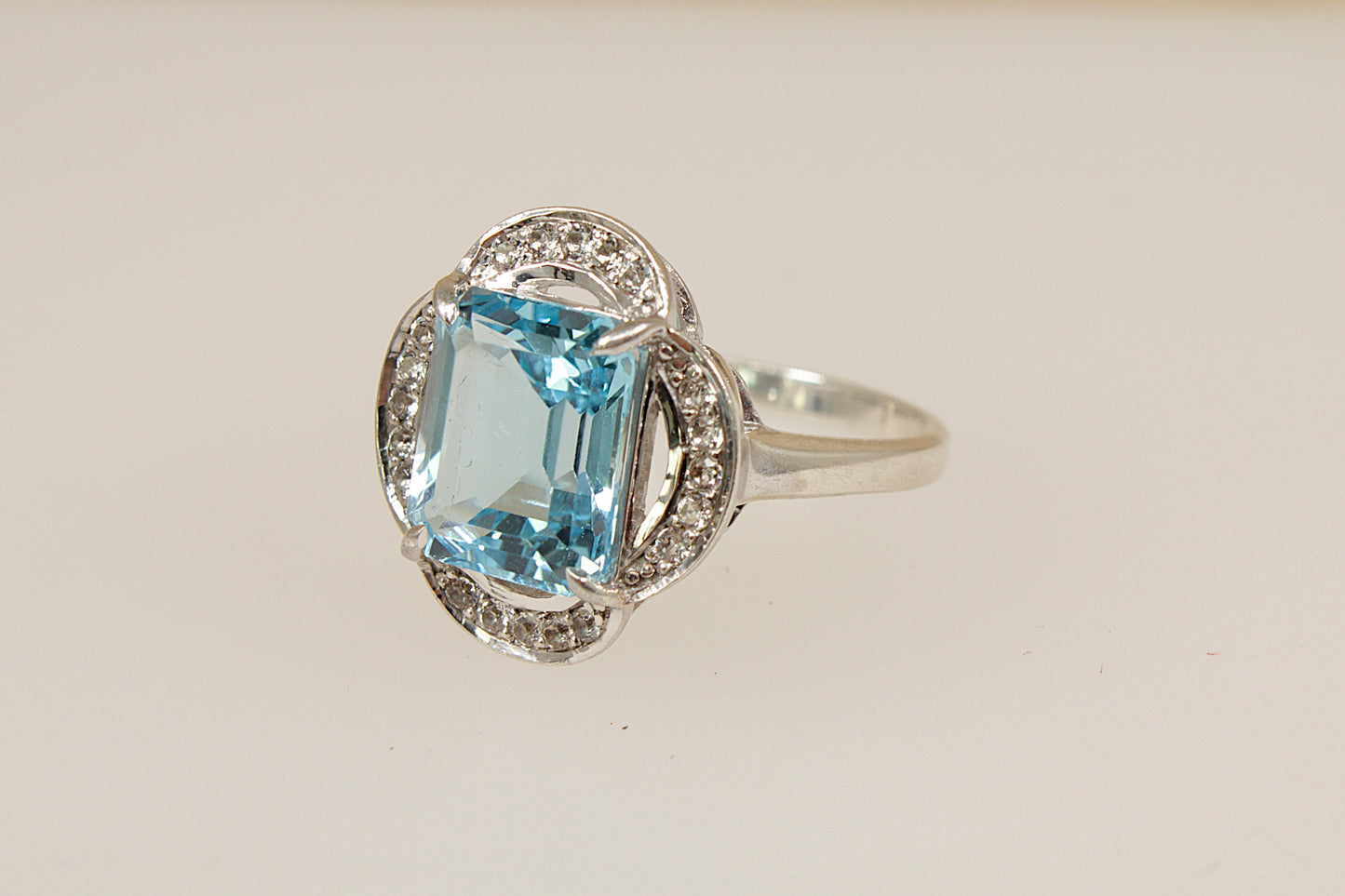Silver ring with a blue and white topaz gemstone on a light background