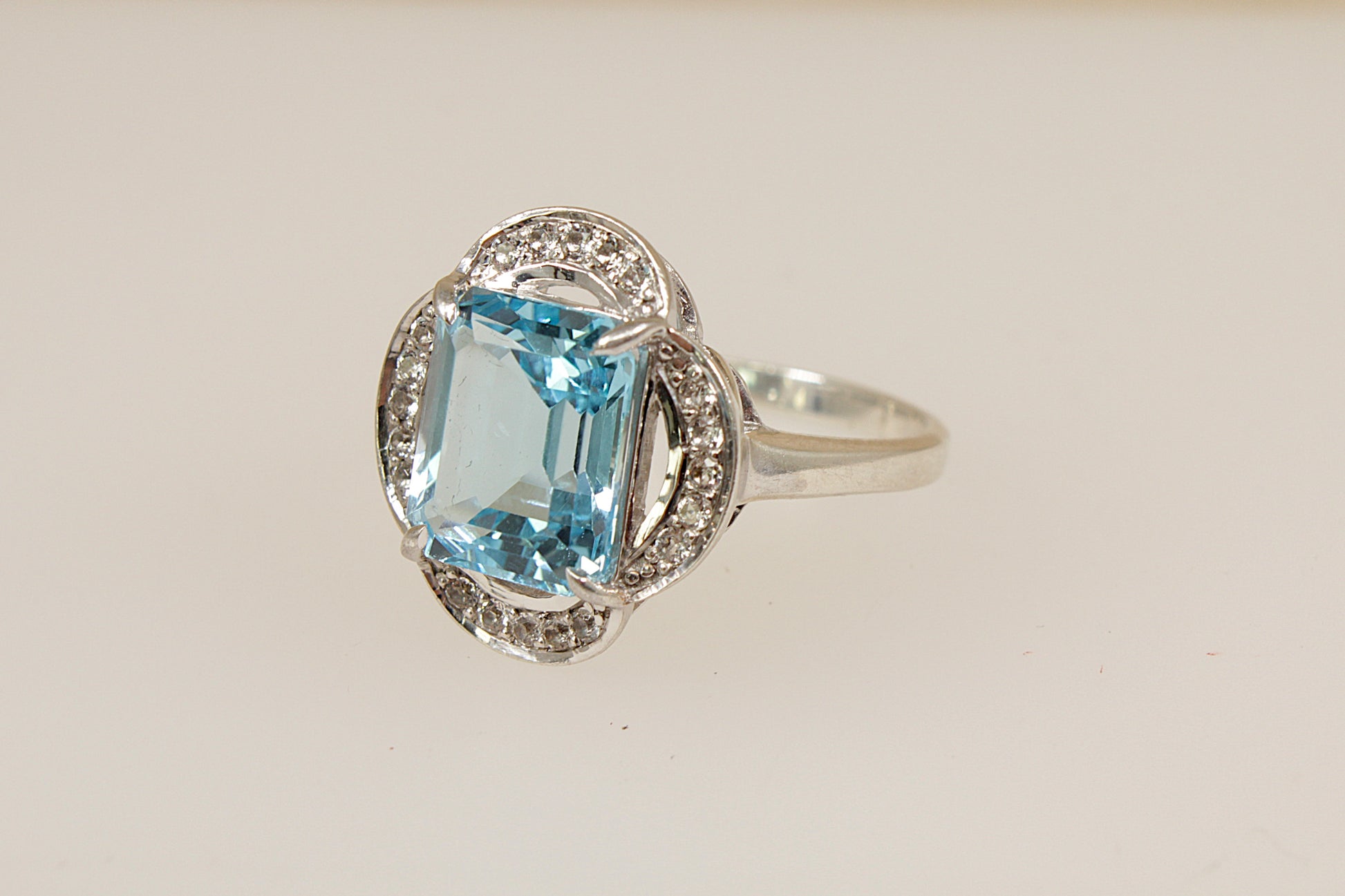 Silver ring with a blue and white topaz gemstone on a light background