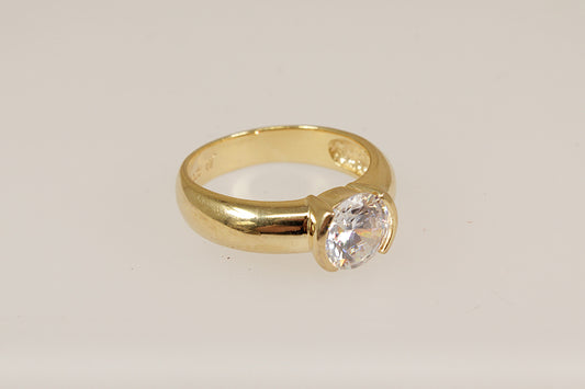 Silver gold plated ring with a c.z. diamond simulant gemstone on a light beige background