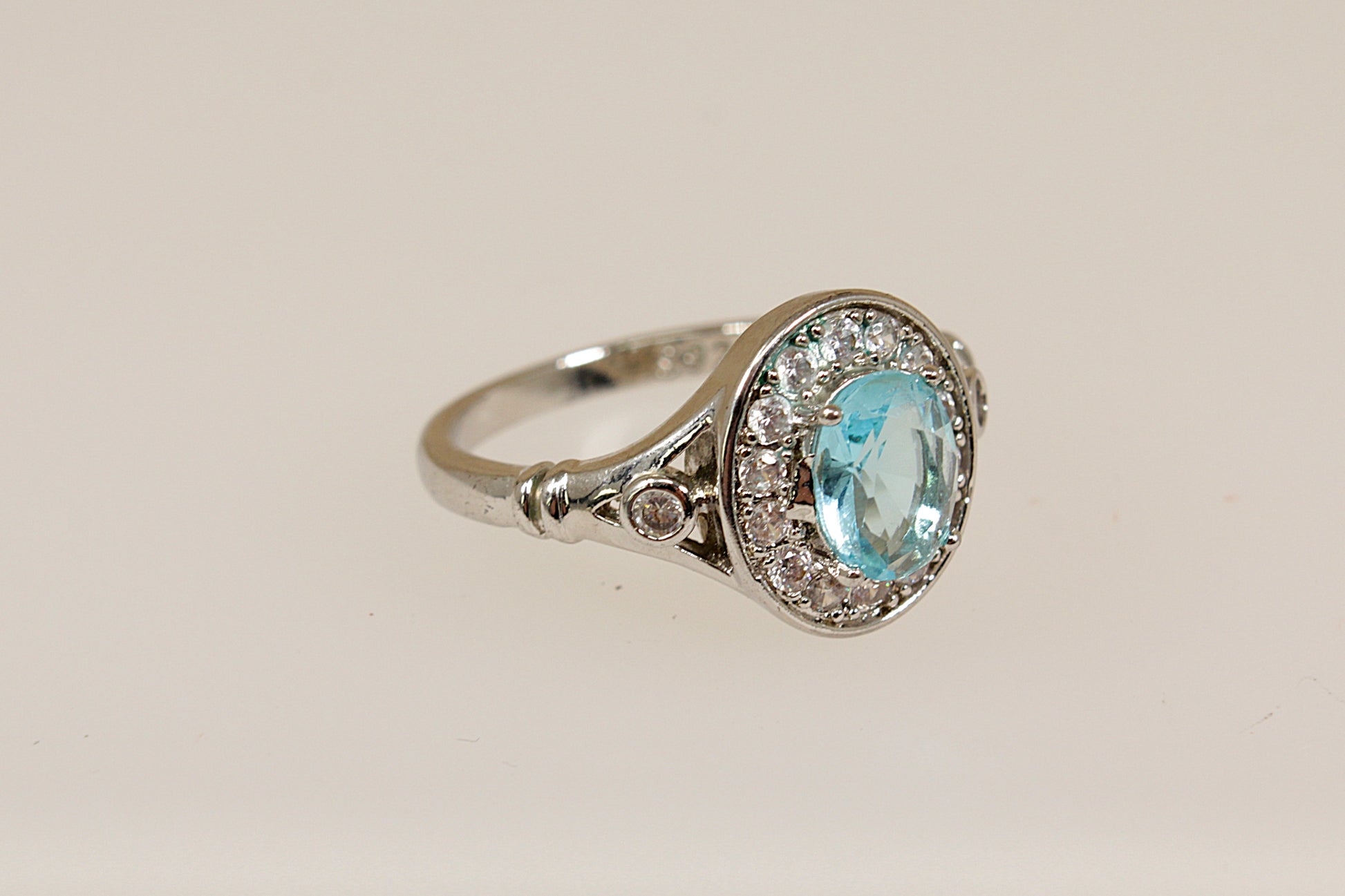 Silver ring with a blue gemstone on a beige background