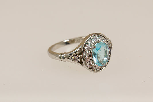 Silver ring with a blue gemstone on a beige background