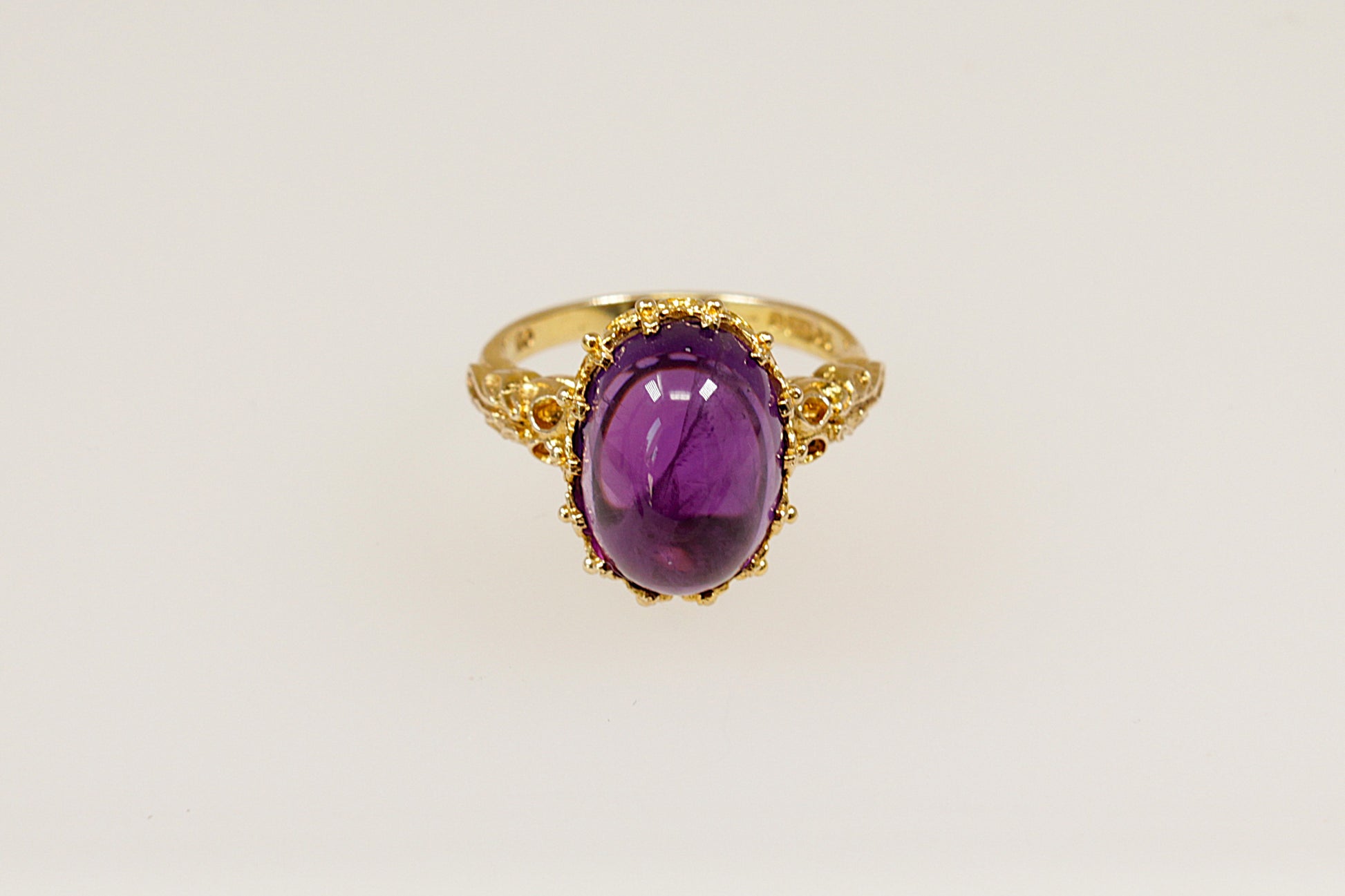 This 9ct Gold ring is a truly magnificent vintage statement with regal presence!
It features a large, high-domed oval cabochon Amethyst with a deep purple colour, set in an intricate gold basket crown setting. UK finger size P.