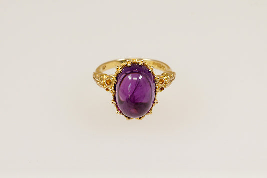 This 9ct Gold ring is a truly magnificent vintage statement with regal presence!
It features a large, high-domed oval cabochon Amethyst with a deep purple colour, set in an intricate gold basket crown setting. UK finger size P.