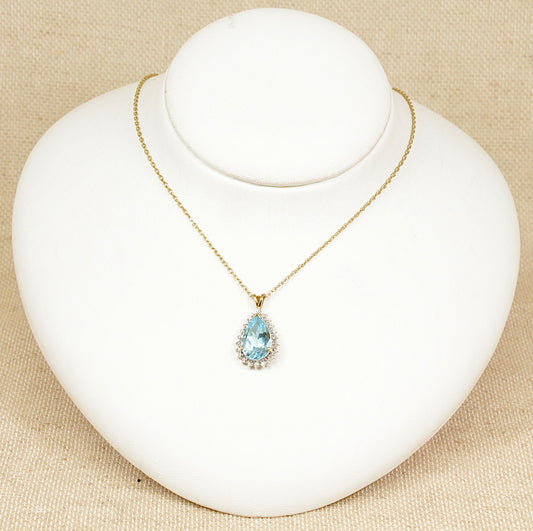 A 9ct gold blue topaz pendant with four diamond accents.  The pendant sits on an 18 inch 9ct Gold ‘Prince of Wales’ style chain, pendant and chain are in excellent condition. The pendant has Birmingham hallmarks and stamped ‘DIA’ for diamonds, the chain also has Birmingham hallmarks. Topaz: 15 x 10mm, Topaz weight: 5.5ct (estimated).