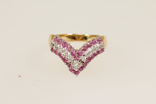 This beautiful 9ct Gold cluster ring is designed in a wishbone shape; featuring 3 bands of gemstones, creating a striking and meaningful design. The two rows of round-cut rubies (24 in total) bring a vibrant deep red colour, symbolising passion and prosperity, while the central row of diamonds adds a touch of brilliance and contrast, enhancing the overall sparkle. The London hallmarks for 1992, UK finger size M.
