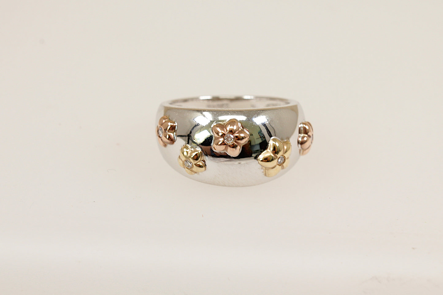 A 9ct white and yellow gold scatter ring on the white gold band it has five yellow gold flower heads each mounted with a central round cut diamond UK finger size O. 