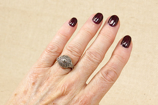 This stunning&nbsp;Art Deco silver and marcasite decorative ring is a beautiful piece of vintage-inspired jewellery.
The Art Deco movement popular from the 1920’s to 1940’s, is characterised by bold lines and symmetrical patterns; rings from this period often feature intricate designs, as in this case, with a balance of elegance and sophistication.
The combination of silver and marcasite in this ring gives it a classic and timeless look; stamped 925 for sterling silver. UK Finger size N.
