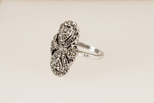 Vintage silver art deco marcasite  ring with intricate design on a beige background
