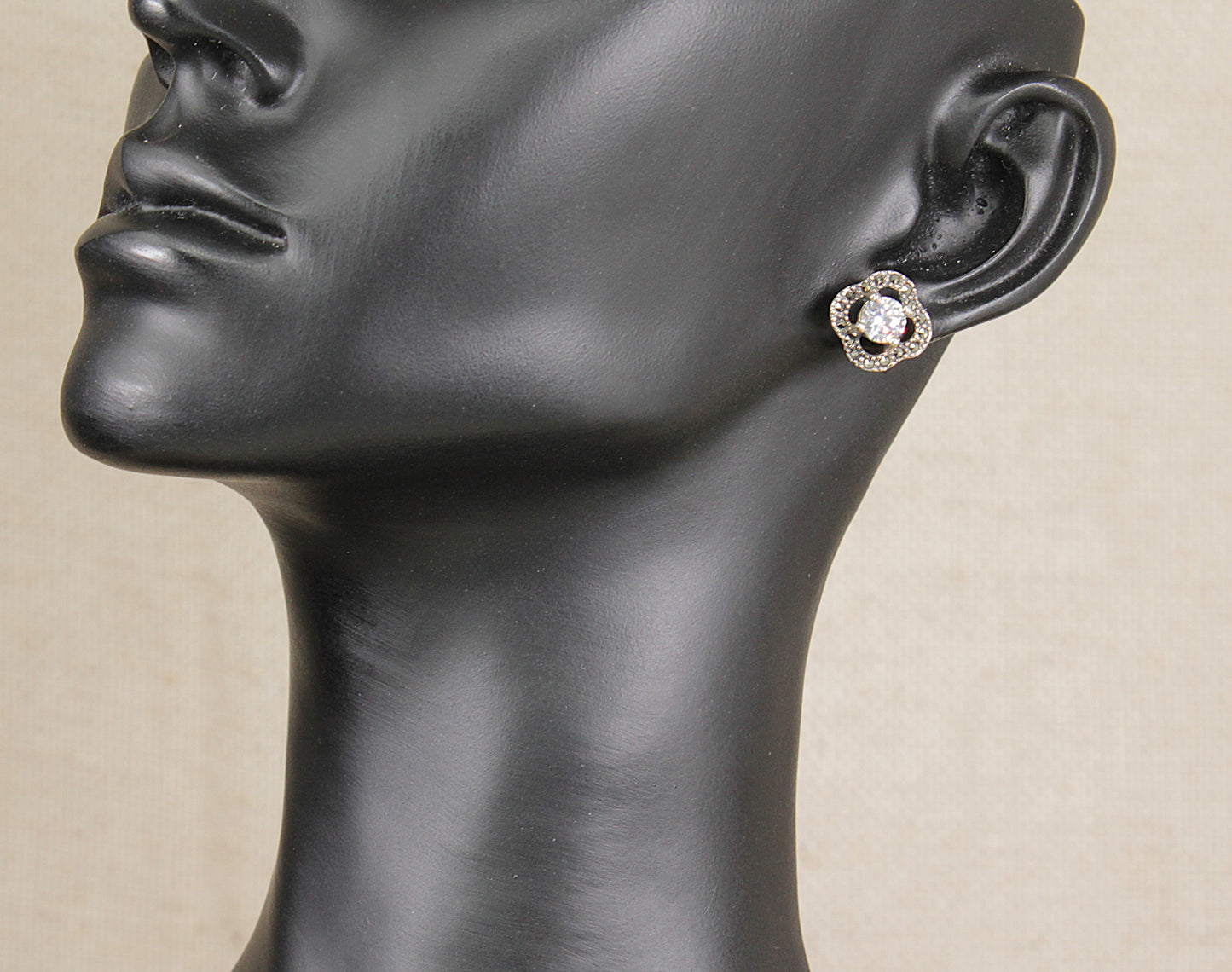 Silver cubic zirconia and marcasite  Earring on a black mannequin head against a beige background