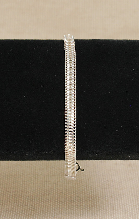 Silver snake chain bracelet on a black bracelet stand on a beige background 