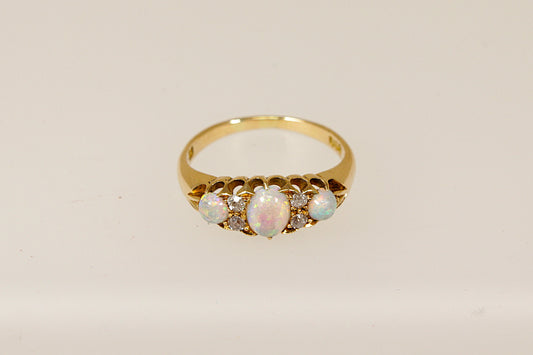 An Edwardian 18ct gold ring with three cabochon cut fire opals and four rose cut diamonds set in a galleried design, The ring is in excellent condition and inside the band it is stamped 18 for 18ct Gold. It also has the maker mark A & W. 
UK Finger size P.