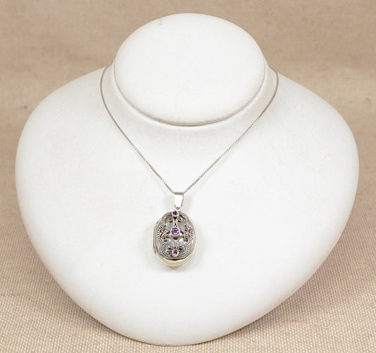 Vintage silver pendant locket necklace  with amethyst gemstones on a white bust against a beige background