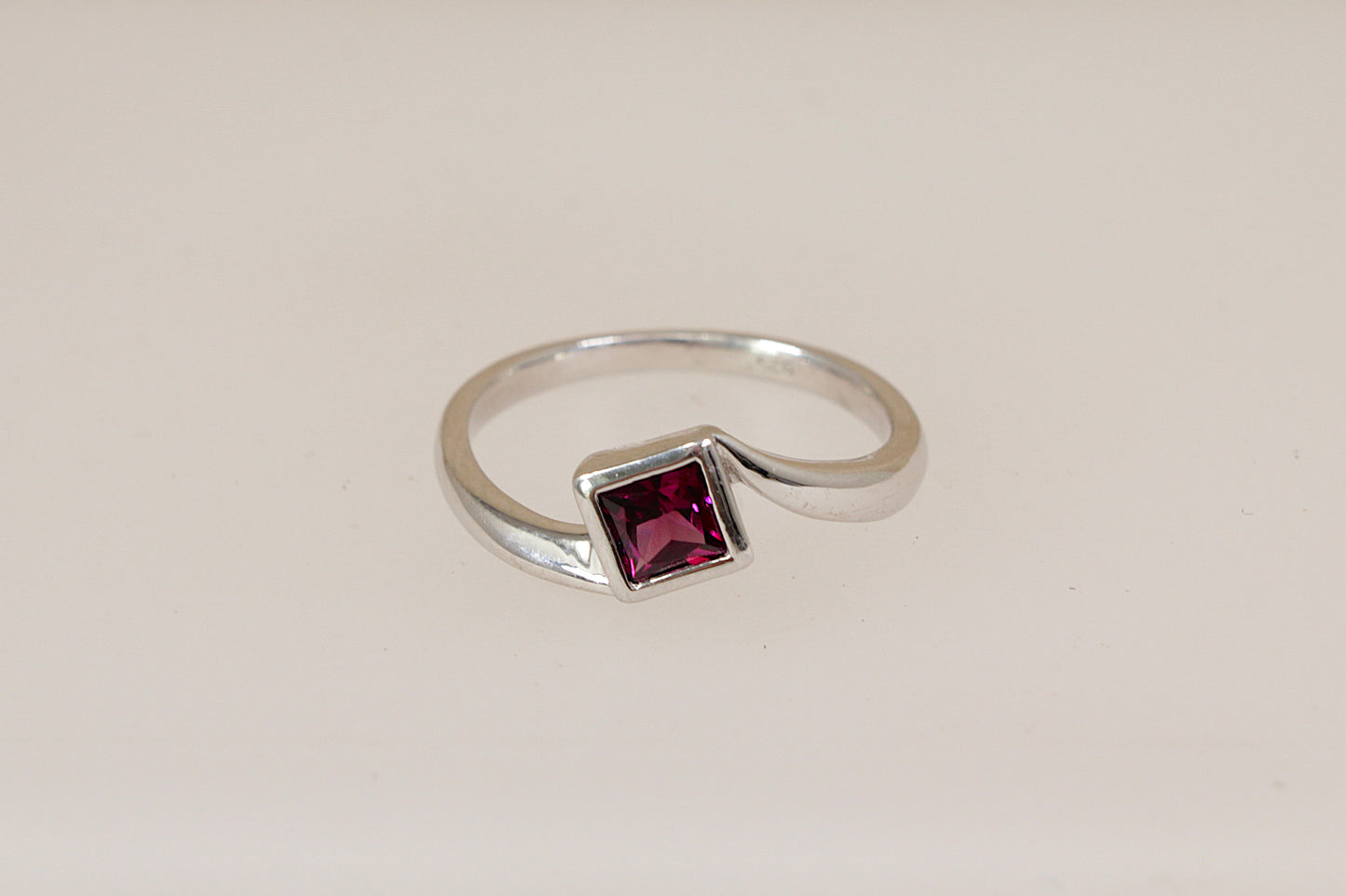 Sterling silver rhodolite solitaire ring on a white background