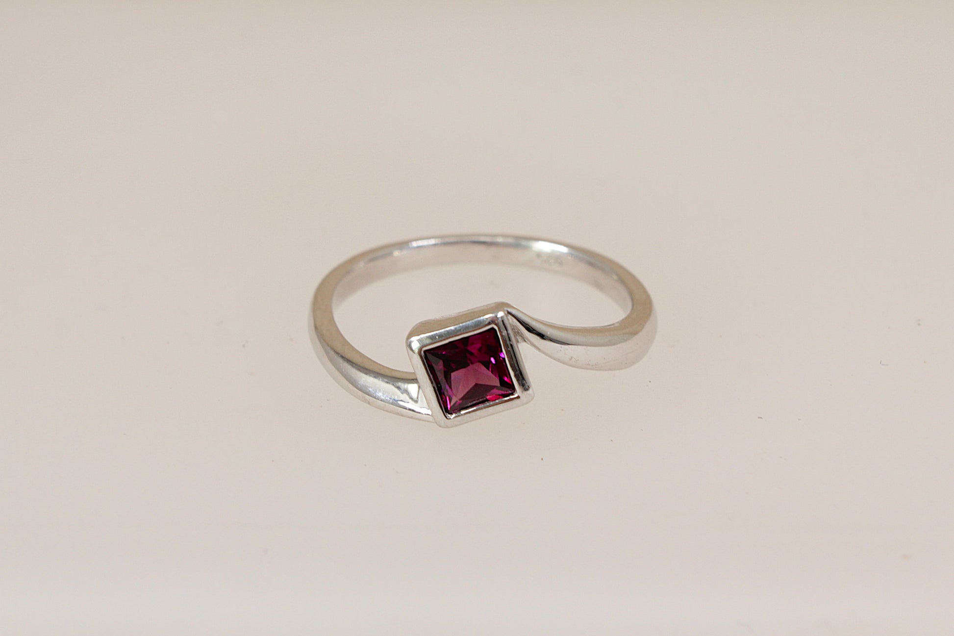 Sterling silver rhodolite solitaire ring on a white background