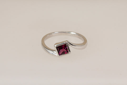 Sterling silver rhodolite solitaire ring on a white background
