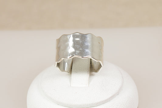 Brand new Silver band statement ring on a white stand with a beige background