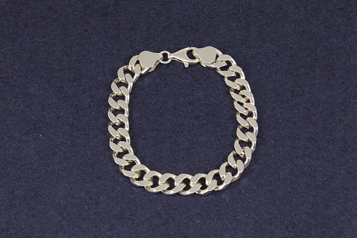 Heavy Silver curb link chain bracelet on a dark blue background