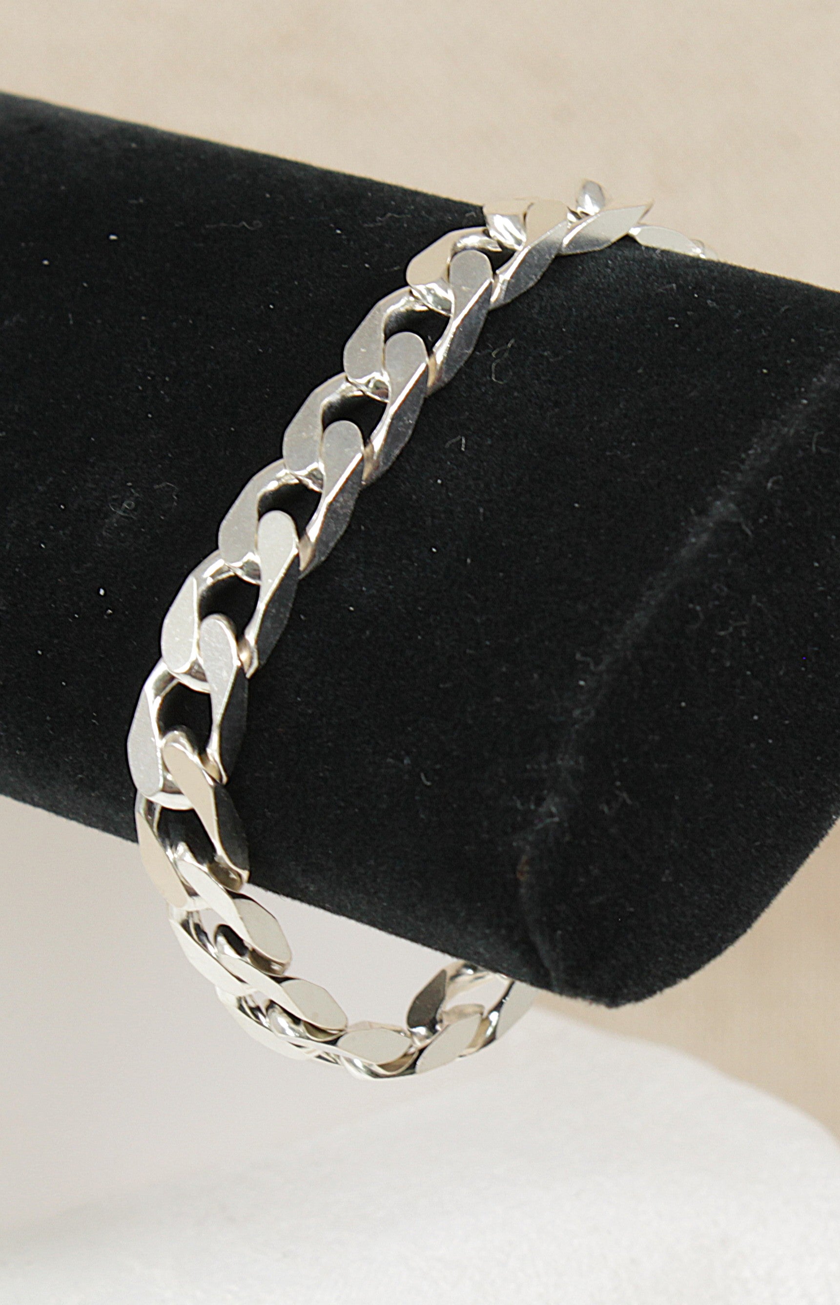 Silver Curb link chain bracelet on a black velvet cushion