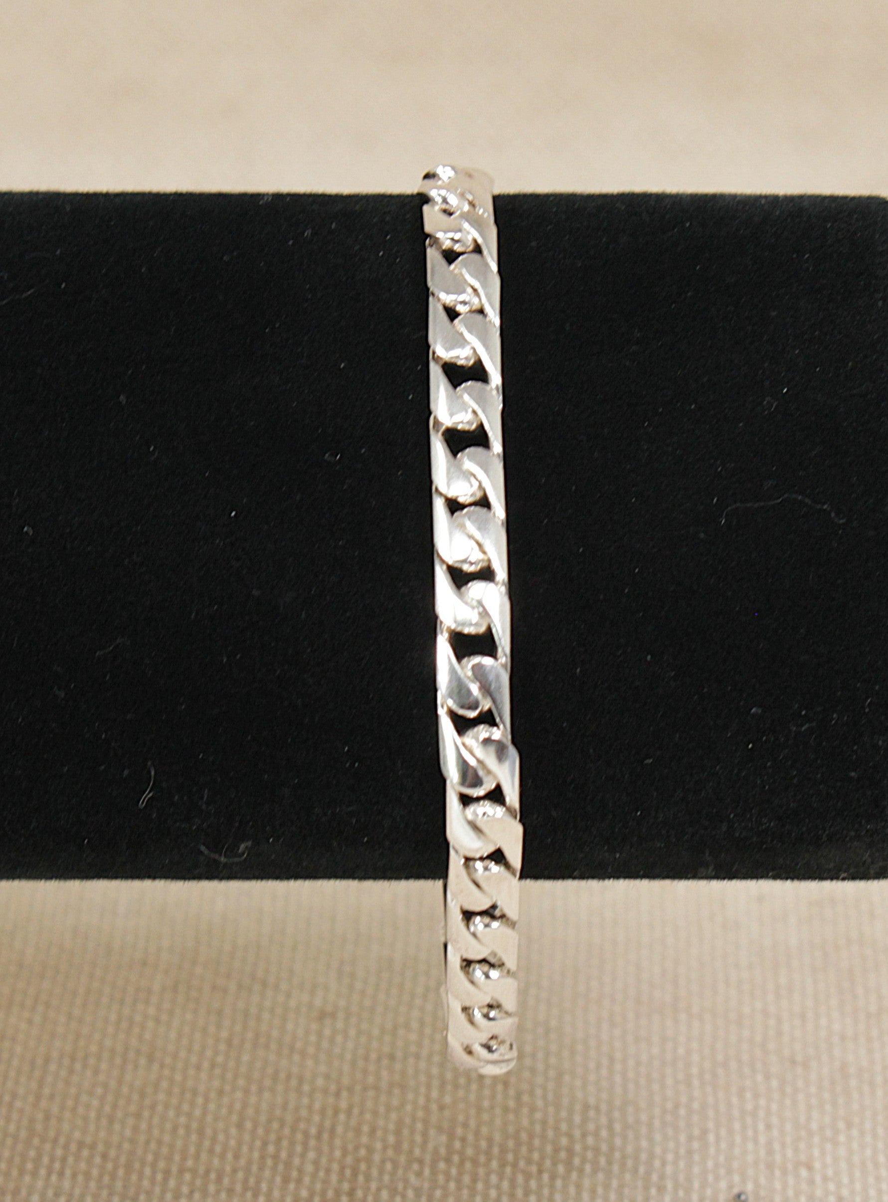 Silver Italian curb link chain bracelet on a black cushion