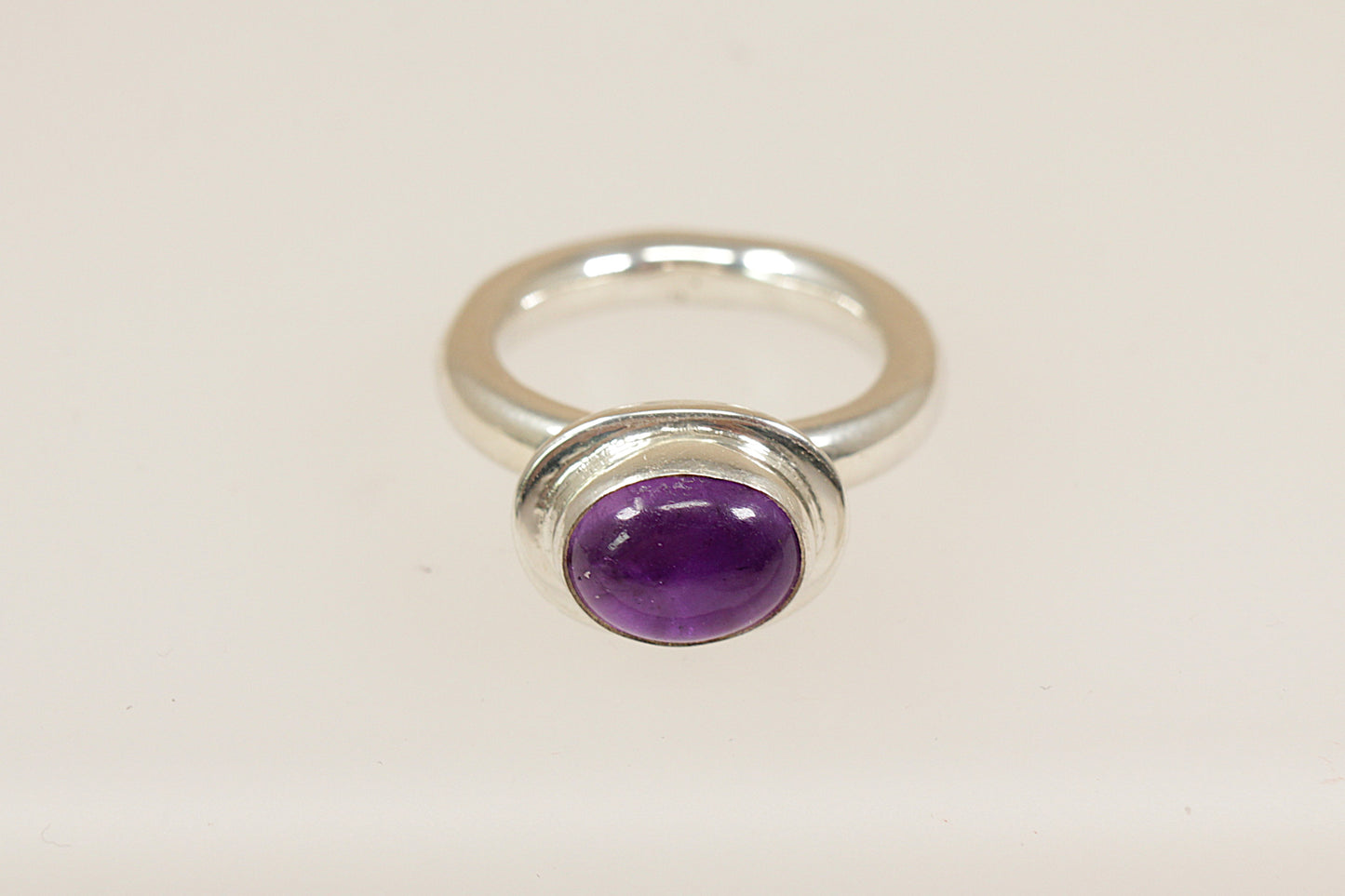 A Sterling silver raised cabochon purple amethyst solitaire statement ring, the ring is stamped 925 for sterling silver and is a UK finger size M.