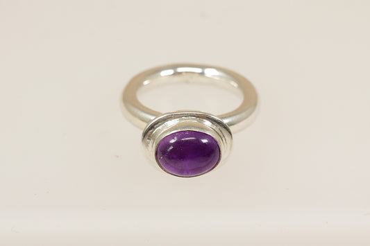 A Sterling silver raised cabochon purple amethyst solitaire statement ring, the ring is stamped 925 for sterling silver and is a UK finger size M.