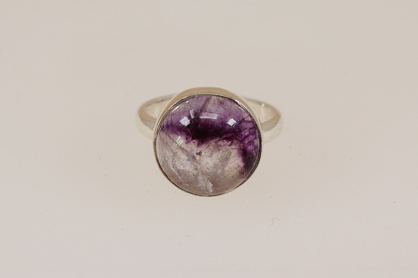 Silver ring with a rare sought after Blue John  gemstone on a beige background