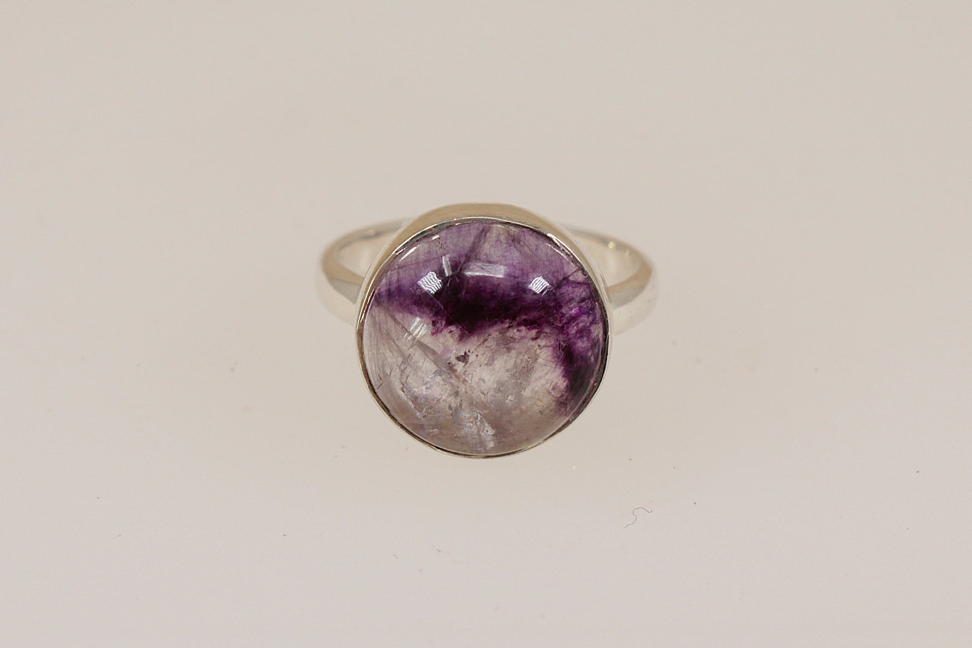Silver ring with a rare sought after Blue John  gemstone on a beige background