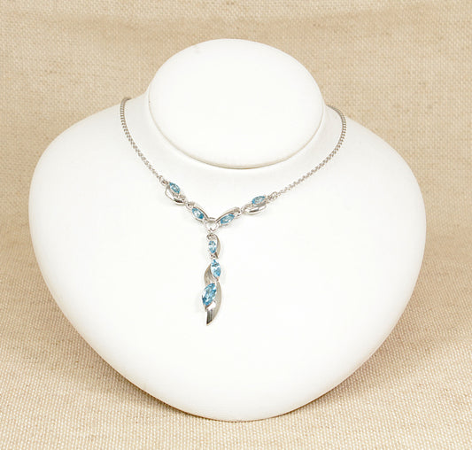 A sterling silver necklet necklace with blue spinel gemstones displayed on a white mannequin bust.