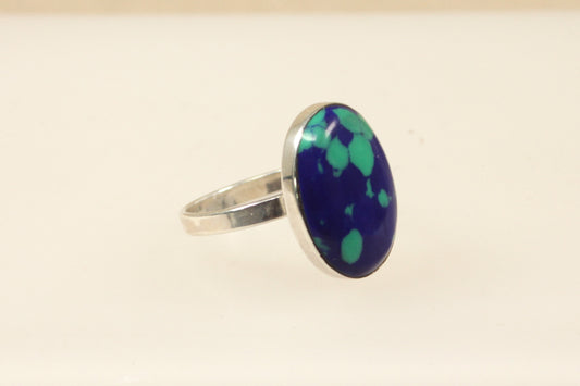An oval blue spotted design ring with a sterling silver setting.