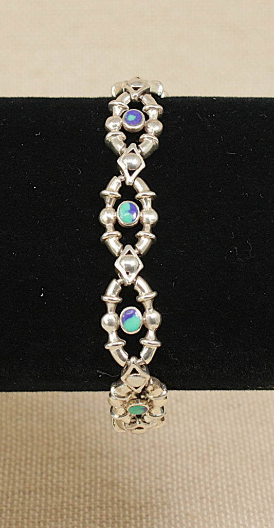 Silver bracelet-with blue green detail on a black and beige background
