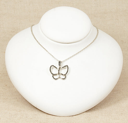 A silver butterfly pendant necklace with marcasite stones on the edges displayed on a white mannequin.