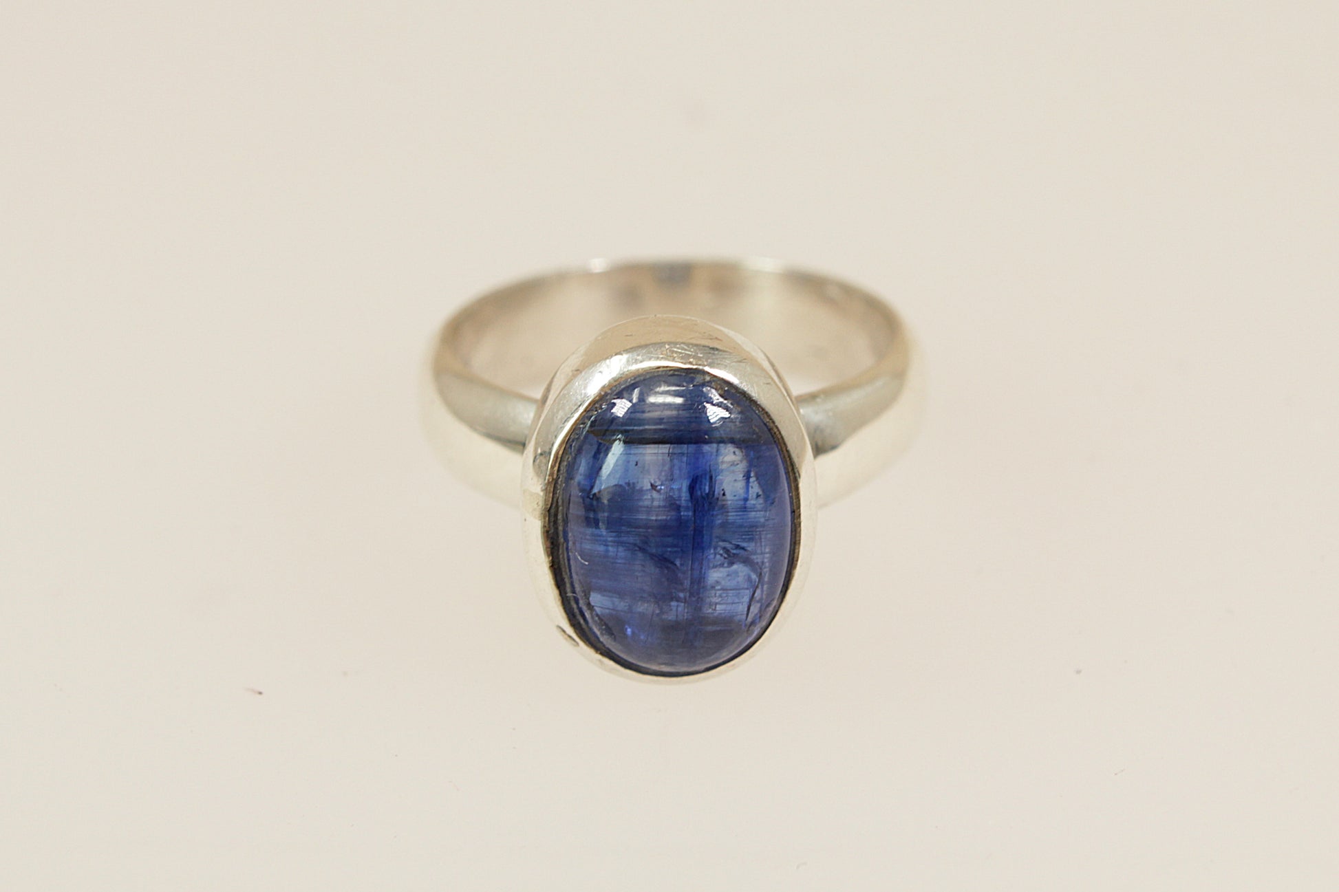 A striking sterling silver ring featuring a smooth, cabochon-cut blue topaz in a sleek bezel setting, male or female, uk finger size O.