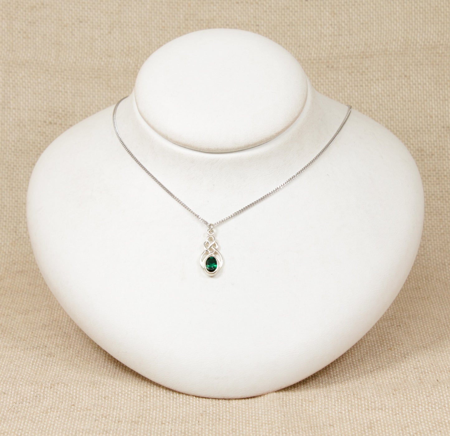 Silver Celtic Knot Crystal Pendant Necklace. This cute Silver pendant has an oval green crystal set in a Celtic knot design setting. The pendant is stamped 925 for sterling silver also the pendant sits on a silver 18 inch flat curb chain which is also stamped 925.