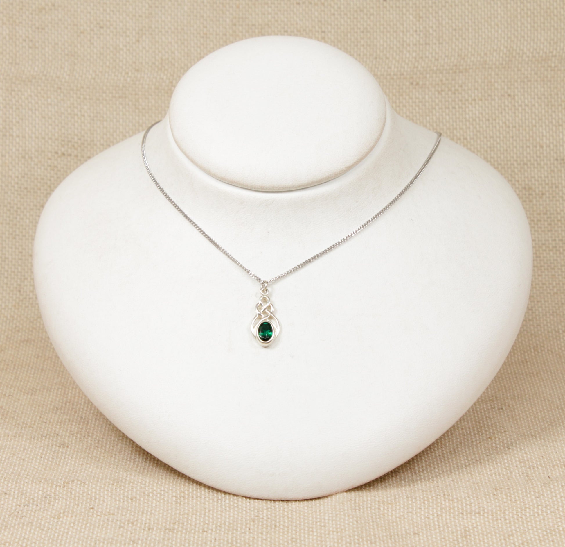 Silver Celtic Knot Crystal Pendant Necklace. This cute Silver pendant has an oval green crystal set in a Celtic knot design setting. The pendant is stamped 925 for sterling silver also the pendant sits on a silver 18 inch flat curb chain which is also stamped 925.