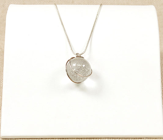 This pretty Silver pendant has a round Quartz Crystal ball set into a decorative silver setting. The pendant sits on a 22 inch silver snake chain. The chain is stamped 925 for sterling silver.