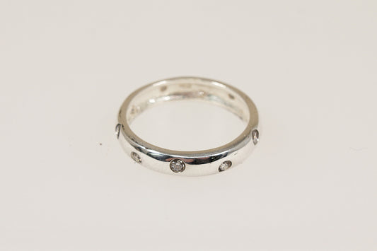 This stylish and elegant band ring has inset crystals running all around the band, combined with the rounded edges, this creates a modern yet timeless look. The polished smooth finish provides a comfortable feel for everyday wear and it would make a perfect stacking ring. It is stamped 925 for sterling silver.