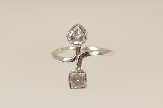 Silver ring with two cz cubic zirconia diamond simulant gemstones on a beige background