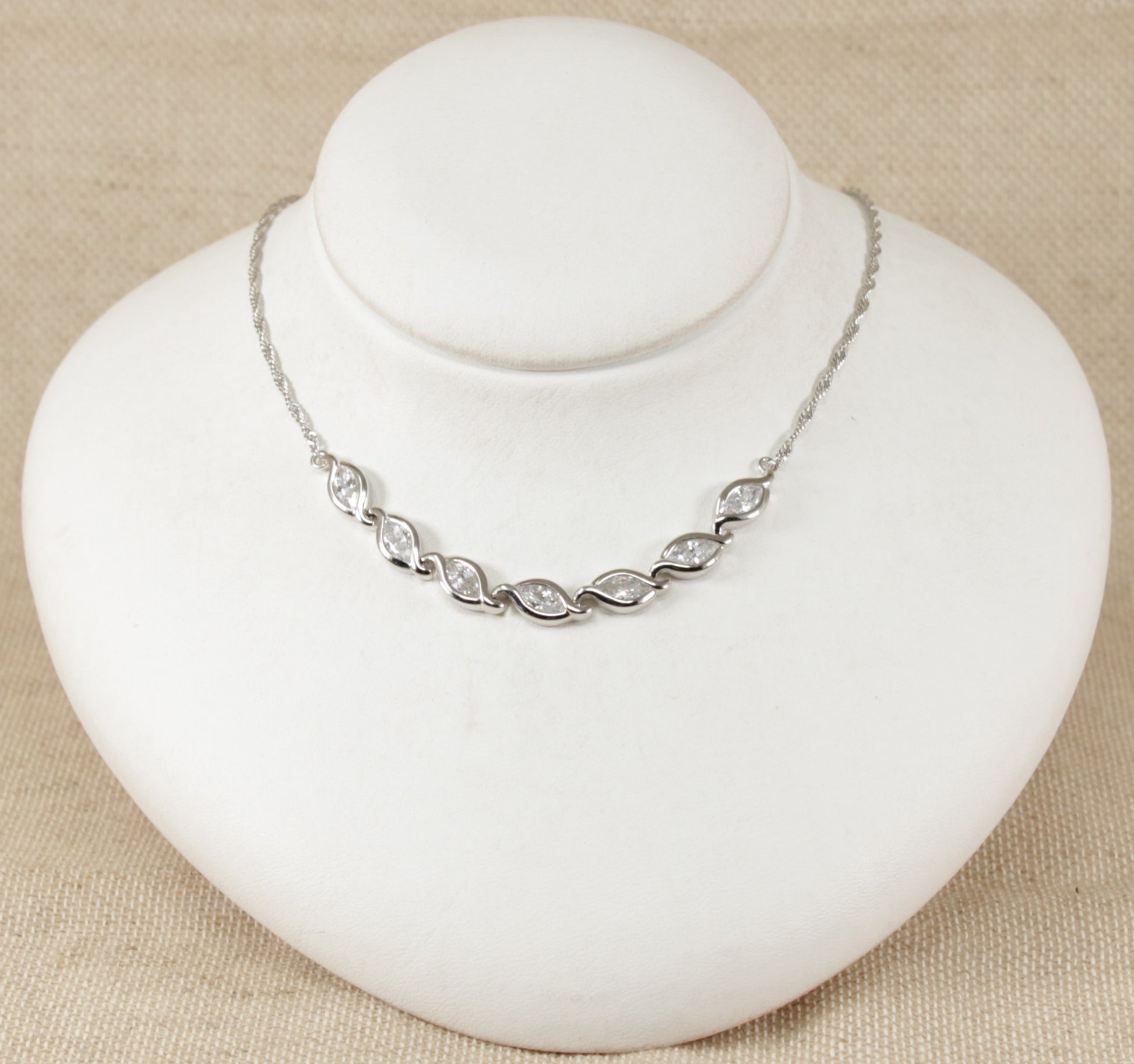 This stunning necklet has 7 marquise cut sparkly Cubic Zirconia gemstones set in handcrafted silver. Each link has a marquise shape silver design setting to match the CZ gemstone. At each end of the links is a fancy twist design silver chain. It is in excellent condition, stamped 925 for sterling silver. Total length : 16 ½ inches.