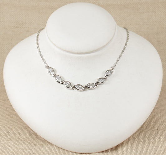 This stunning necklet has 7 marquise cut sparkly Cubic Zirconia gemstones set in handcrafted silver. Each link has a marquise shape silver design setting to match the CZ gemstone. At each end of the links is a fancy twist design silver chain. It is in excellent condition, stamped 925 for sterling silver. Total length : 16 ½ inches.